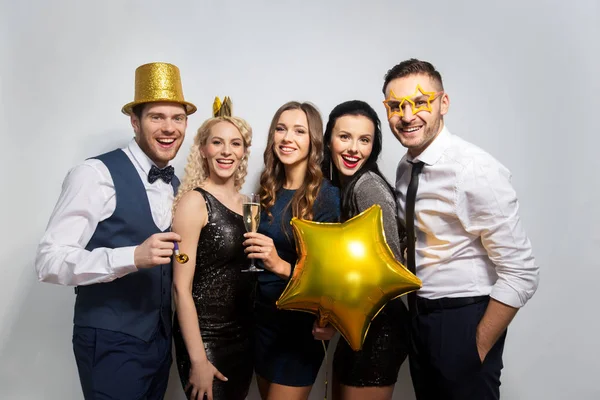 Amis heureux avec des accessoires de fête dorés posant — Photo