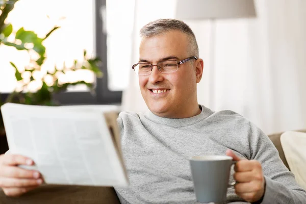 Hombre leyendo el periódico y tomando café en casa — Foto de Stock