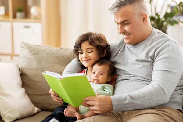 Glücklicher Vater mit Söhnen, die zu Hause Buch lesen — Stockfoto