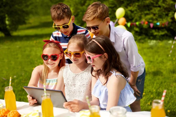 Glückliche Kinder mit Tablet-PC auf Geburtstagsparty — Stockfoto