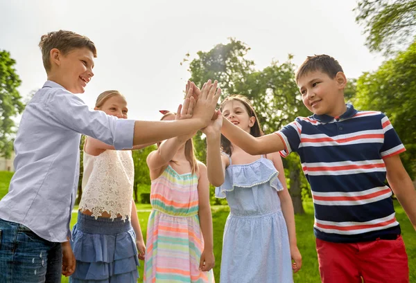 Grupo de niños felices haciendo alta cinco al aire libre —  Fotos de Stock