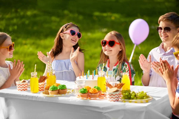 Glada barn med tårta på födelsedagsfest i sommar — Stockfoto
