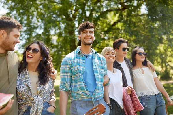 Amici con la chitarra andare al picnic al parco — Foto Stock