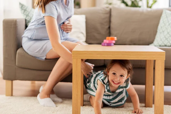 Zwangere moeder en dochter spelen thuis — Stockfoto