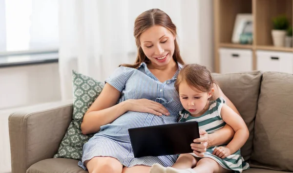 Schwangere Mutter und Tochter mit Tablet-PC — Stockfoto