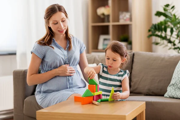 Pregnant mother and daughter with toy blocks — Stock Photo, Image