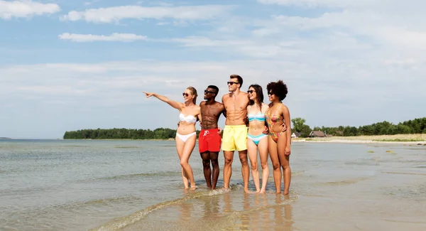 Amigos felices abrazándose en la playa de verano — Foto de Stock