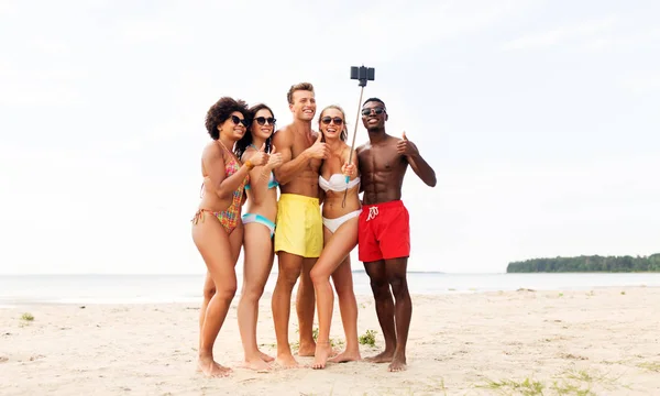 Amici prendendo selfie sulla spiaggia e mostrare pollici in su — Foto Stock
