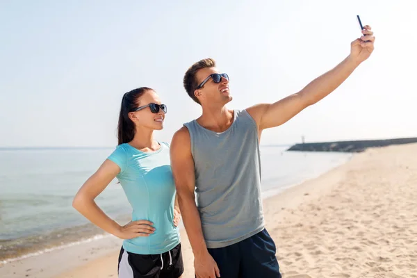 Para biorąc selfie przez smartfon na plaży — Zdjęcie stockowe