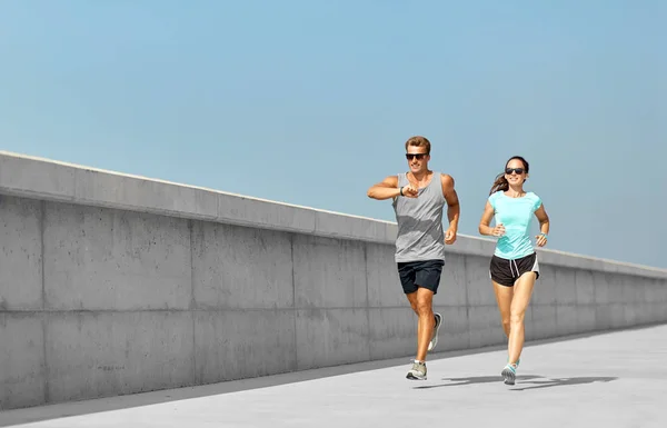 Paar in sporten kleren buitenshuis uitvoeren — Stockfoto