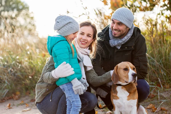 Familia feliz con perro beagle al aire libre en otoño —  Fotos de Stock