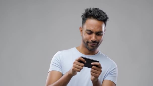 Homem indiano feliz jogando jogo no smartphone — Vídeo de Stock