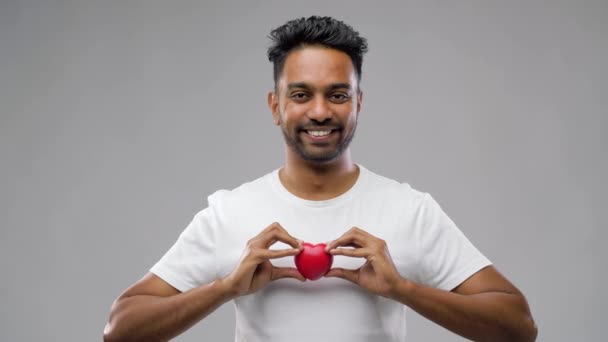 Hombre indio con corazón rojo sobre fondo gris — Vídeo de stock