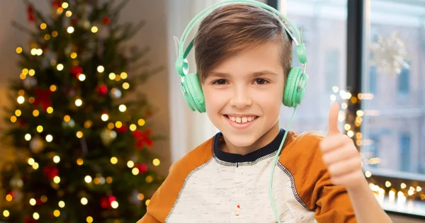 Chłopiec w słuchawki Wyświetlono kciuk w na Boże Narodzenie — Zdjęcie stockowe