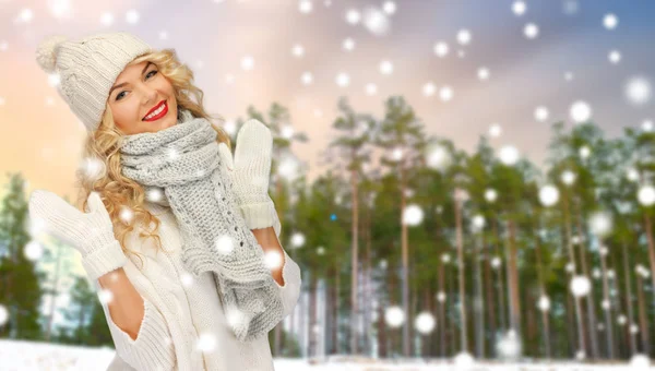 Gelukkige vrouw in muts en sjaal over winter forest — Stockfoto