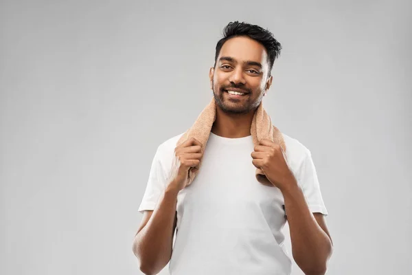 Hombre indio sonriente con toalla sobre fondo gris —  Fotos de Stock