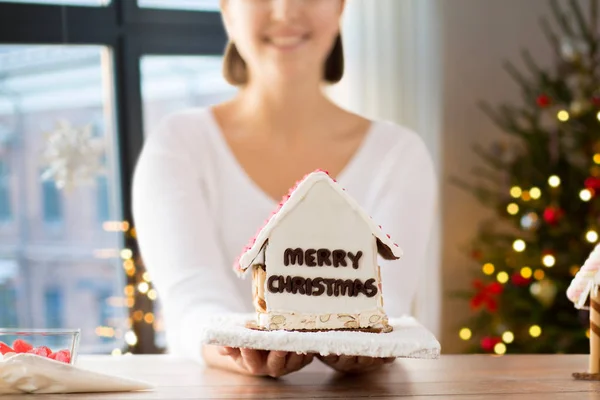 Nahaufnahme einer Frau mit weihnachtlichem Lebkuchenhaus — Stockfoto