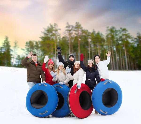 Amigos felizes com tubos de neve ao ar livre no inverno — Fotografia de Stock