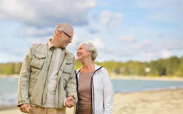 Happy senior couple over beach background — Stock Photo, Image