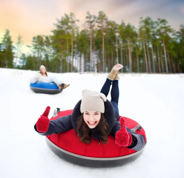 Szczęśliwy nastolatkę, przesuwając w dół wzgórza na snow tube — Zdjęcie stockowe