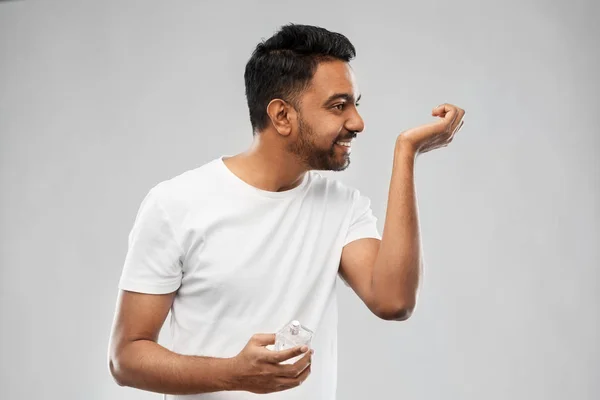 Szczęśliwy człowiek indian z perfum na szarym tle — Zdjęcie stockowe