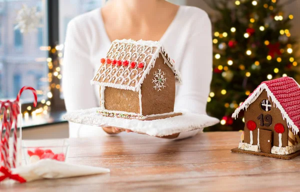 Primer plano de la mujer con la casa de jengibre de Navidad —  Fotos de Stock