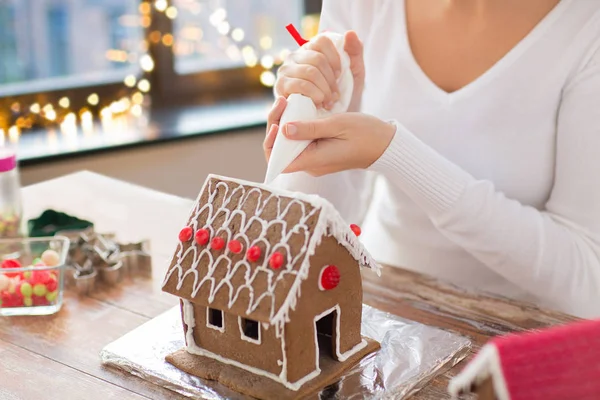 Mujer haciendo casas de jengibre en Navidad —  Fotos de Stock