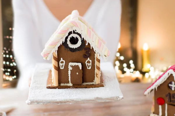 Nahaufnahme einer Frau mit weihnachtlichem Lebkuchenhaus — Stockfoto
