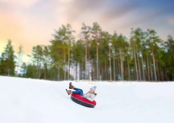 Heureux adolescent fille glissant vers le bas colline sur neige tube — Photo