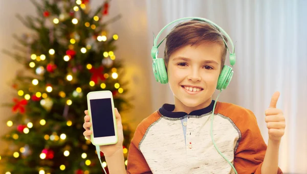 Niño con smartphone y auriculares en Navidad —  Fotos de Stock