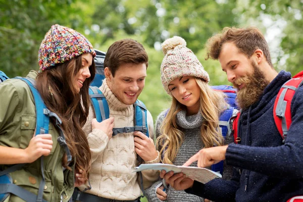 Friends or travelers hiking with backpacks and map — Stock Photo, Image