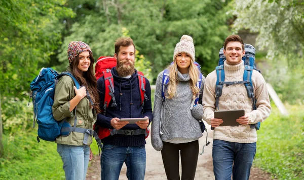 Friends or travelers with backpacks and tablet pc — Stock Photo, Image