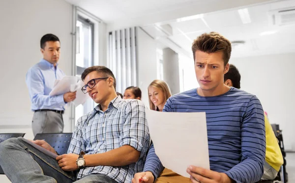 Students with tests and teacher at lecture hall — Stock Photo, Image