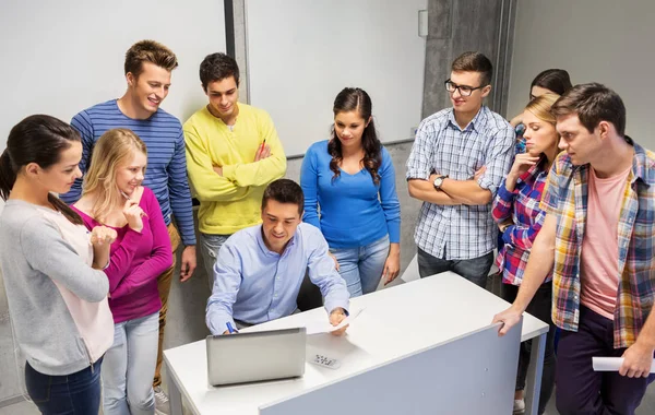 Students and teacher with papers and laptop — Stock Photo, Image