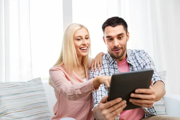 Aufgeregtes Paar mit Tablet-Computer zu Hause — Stockfoto