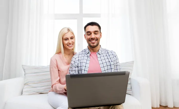 Smiling happy couple with laptop at home — Stock Photo, Image