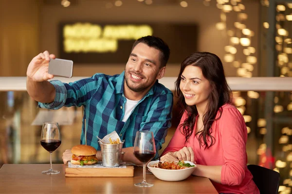 Casal tirando selfie por smartphone no restaurante — Fotografia de Stock