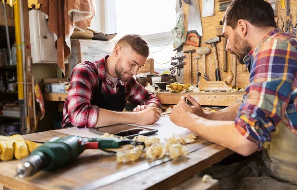 Carpinteros con planos trabajando en el taller —  Fotos de Stock