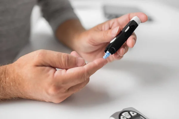 Senior man with glucometer checking blood sugar — Stock Photo, Image