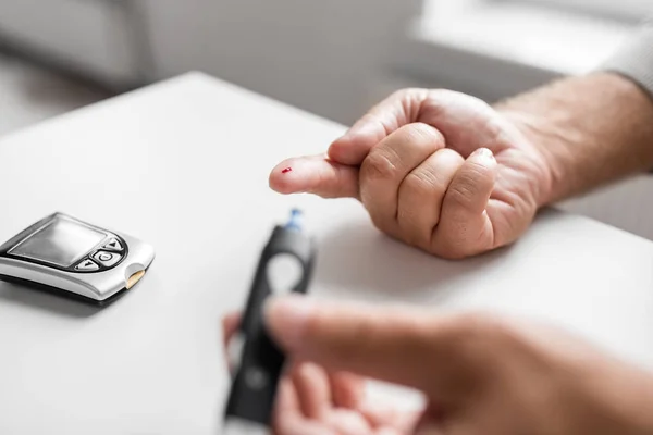 Äldre man med Glukometer kontrollera blodsocker — Stockfoto