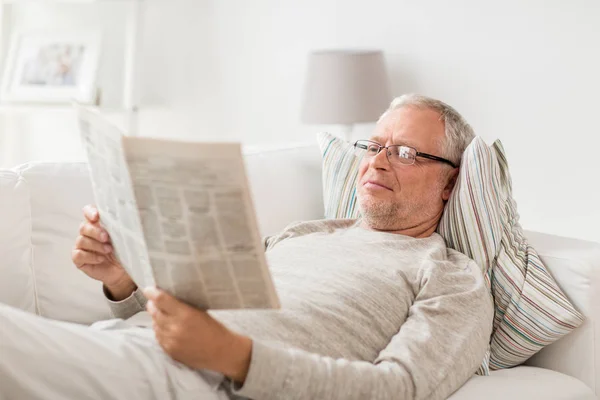 Senior liest Zeitung zu Hause — Stockfoto