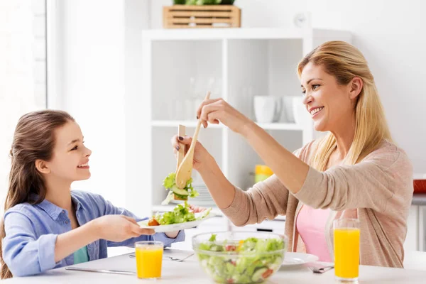 Família feliz comer salada em casa cozinha — Fotografia de Stock