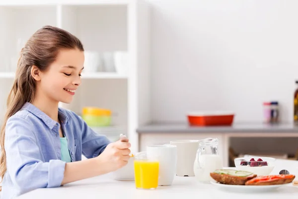 Menina feliz tomando café da manhã em casa — Fotografia de Stock