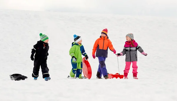 Mutlu küçük kışın sledging kızaklarımız ile çocukların — Stok fotoğraf