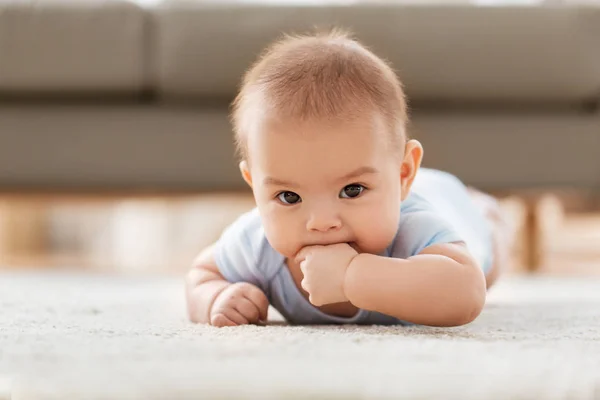 家の床の上に横たわる甘い小さなアジアの赤ちゃん男の子 — ストック写真