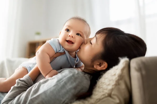 Feliz madre besando pequeño bebé hijo en casa —  Fotos de Stock