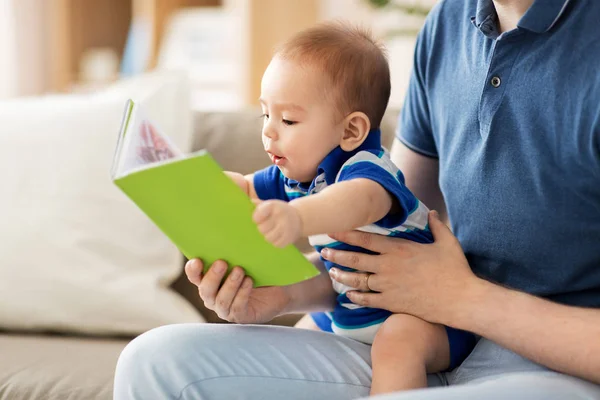 Babyjongen en vader met boek thuis — Stockfoto