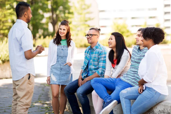 Amigos internacionais felizes falando no parque — Fotografia de Stock