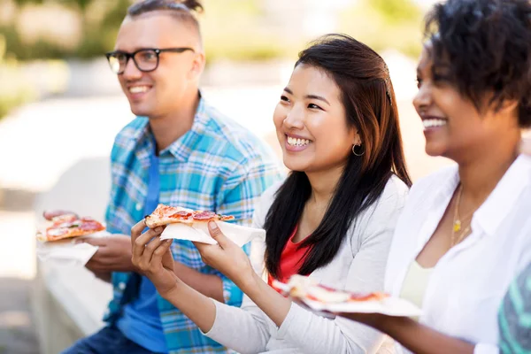 Glückliche Freunde, die draußen Sandwiches und Pizza essen — Stockfoto