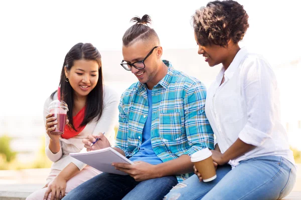 Studenti con taccuino e bevande da asporto — Foto Stock